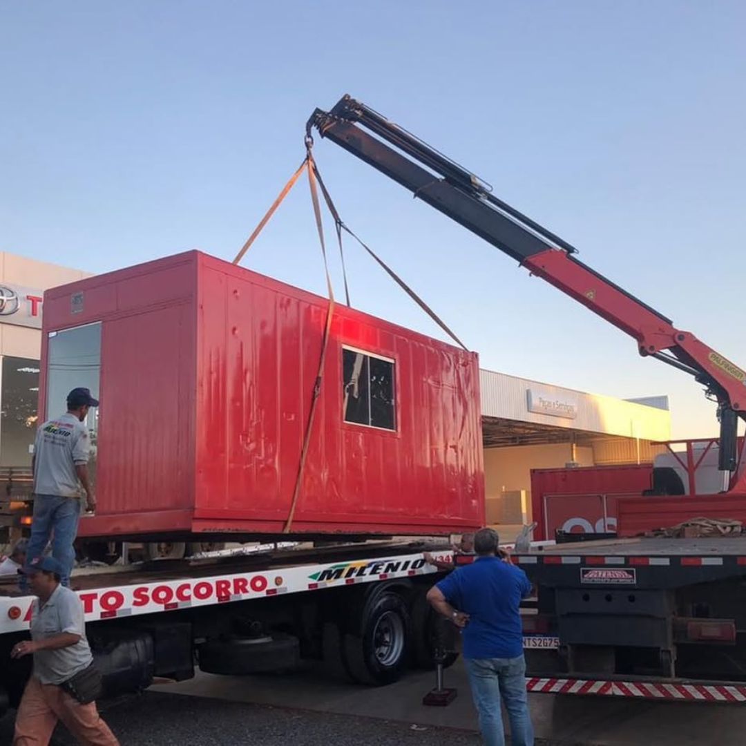 Caminhão munck da Tramel içando um container para transporte