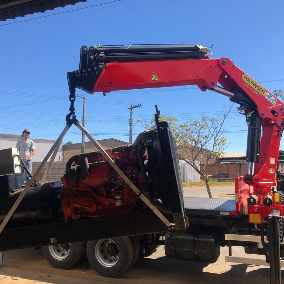 Munck carregando equipamento em galpão